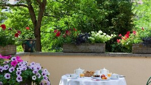 A table set with breakfast items, surrounded by potted plants and greenery. - Hotel Val Du Tech  (Prats-de-Mollo-la-Preste)