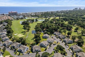 Ein Wohngebiet mit Häusern, einem Golfplatz und einem Gewässer.