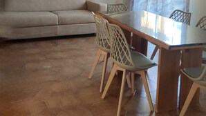 A dining area with a table, chairs, a sofa, and a painting on the wall. - Bagnara, Sweet Home (Bagnara Calabra)
