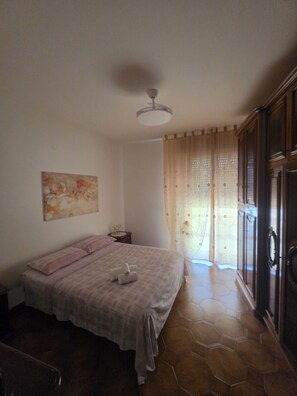 Ein Schlafzimmer mit Bett, einem Gemälde, einem Nachttisch und einem Kleiderschrank.