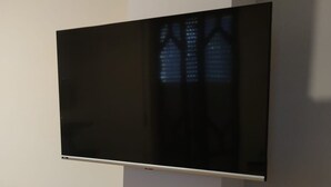 A flat-screen TV mounted on a wall in a room with a tiled floor. - Bagnara, Sweet Home (Bagnara Calabra)