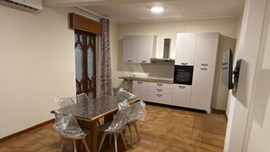 A modern kitchen with white cabinets, a dining area with a table and chairs, and a hexagonal patterned floor. - Bagnara, Sweet Home (Bagnara Calabra)