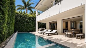 A modern house with a swimming pool, outdoor seating, and a balcony. - Villa Croft | Beverly Hills Luxury Hideaway (Los Angeles)