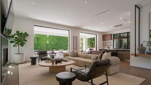 A modern living room with a sofa, coffee table, and a dining area with chairs. - Villa Croft | Beverly Hills Luxury Hideaway (Los Angeles)
