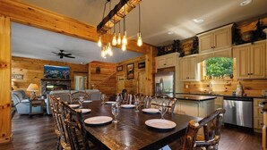 A log cabin interior with a dining area, kitchen, and living room. - Gorgeous 4-bedroom cabin with Views Overlooking Walking Distance to Gatlinburg (Gatlinburg)
