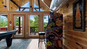 A wooden interior with a pool table, a stool, and a mural of a cartoon character. - Gorgeous 4-bedroom cabin with Views Overlooking Walking Distance to Gatlinburg (Gatlinburg)
