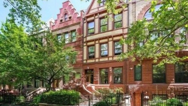 A multi-story building with a brick facade, large windows, and a prominent entrance.