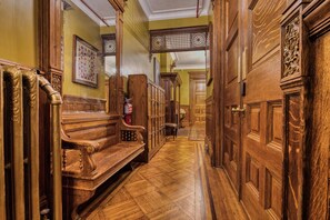 A hallway with wooden benches, a fire extinguisher, and a globe on a cabinet.