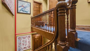 Eine Treppe mit hölzernen Spindeln und einer roten Leitung, die an der Wand verläuft.