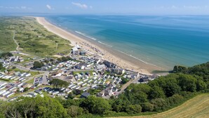 An aerial view of a coastal town with a beach, residential area, and clear blue sea. - Rose Cottage - Sea Views, Hot Tub, Log Burner (Pendine)