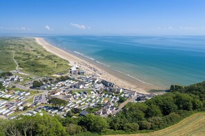 An aerial view of a coastal town with a beach, residential area, and clear blue sea. - Rose Cottage - Sea Views, Hot Tub, Log Burner (Pendine)