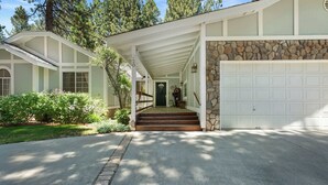 A two-story house with a stone facade, a covered porch, and a garage. - Walk to Snow Summit, AC, Fenced Yard (Big Bear Lake)