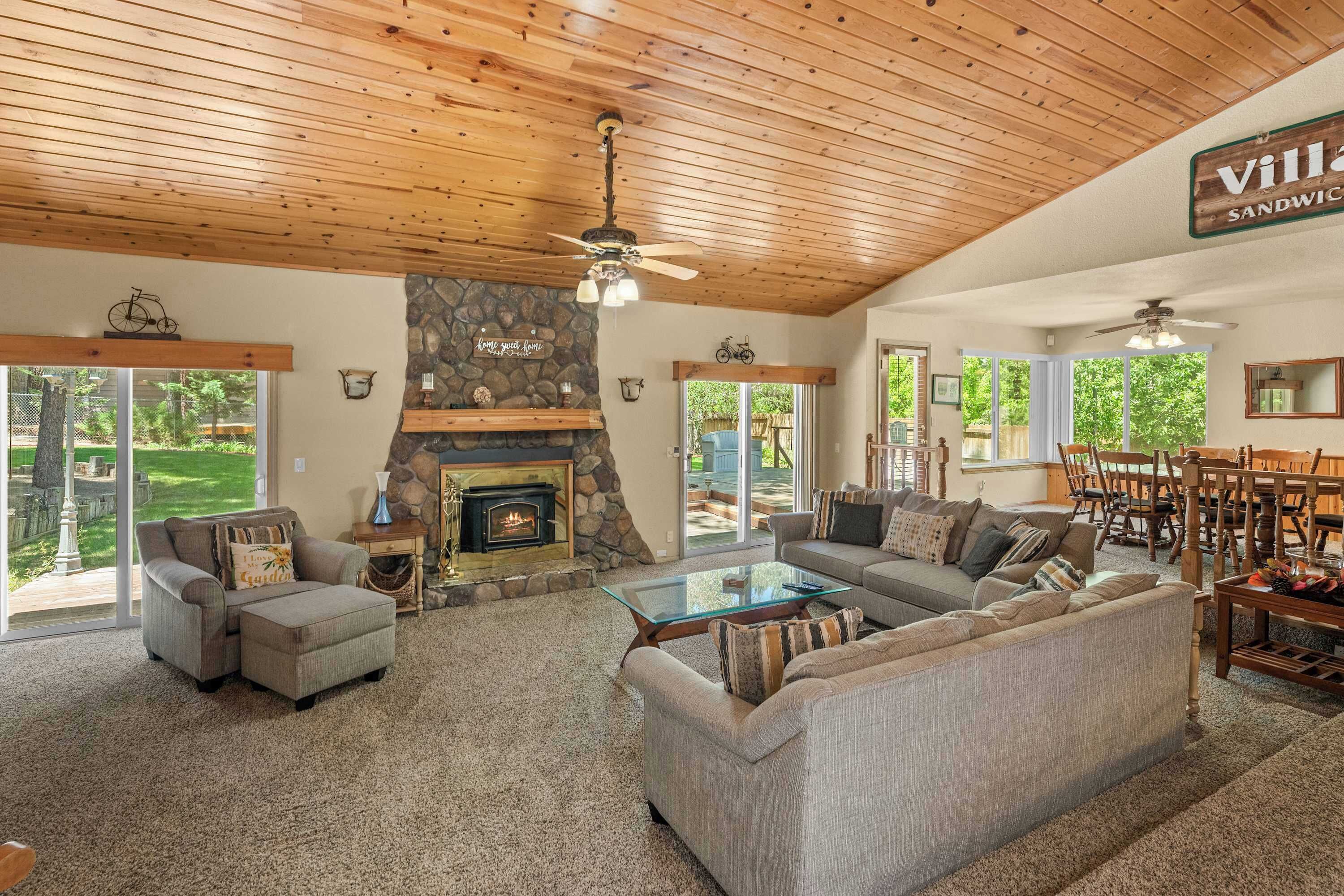 A spacious living room with a fireplace, a stone accent wall, and a sign reading 'Villa Sandwich.'
