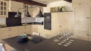 Una cocina moderna con armarios blancos, encimera negra y una viga de techo de madera.