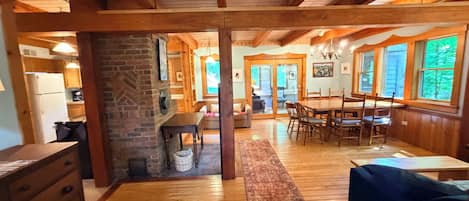 Un intérieur en bois comprenant un coin repas, une cuisine et une cheminée.