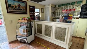 A small, enclosed room with a counter, a refrigerator, and a tiled floor. - HOTEL MEZVALL (Morelia)