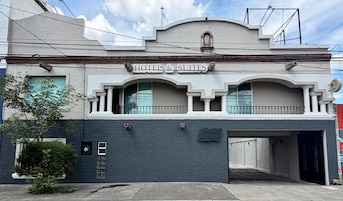 Un hotel con un cartel que dice 'HOTEL & SUITES' y una placa con el nombre 'MEBVALL HOTEL & SUITES'.