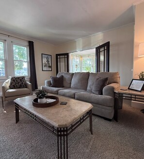 A living room with a sofa, a coffee table, a chair, and a side table.
