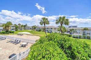 Ein Resort mit Poolbereich, Liegestühlen und einem gepflegten Rasen.