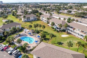A residential area with a swimming pool, multiple houses, and parked cars. - Pool & Golf Course Views at Sandpiper Cove Unit 2014, Beach in Destin, FL (Destin)