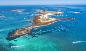 An aerial view of a coastal area with clear blue waters, sandy beaches, and scattered boats. - Renovated Breton house just 150 meters from the beach!  Enclosed Garden, Pets Welcome! (Loctudy)