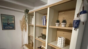 Um interior moderno com prateleiras de madeira, objetos decorativos e um quadro na parede.