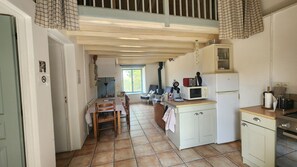 A compact kitchen with a dining area, a built-in stove, and a window providing natural light.
