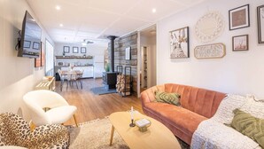 A modern living room with a sofa, chairs, a coffee table, and a fireplace. - Hills Haven - Luxury Riverfront Cottage (Minden Hills)