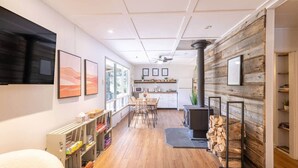 A modern interior with a dining area, kitchen, and a fireplace. - Hills Haven - Luxury Riverfront Cottage (Minden Hills)