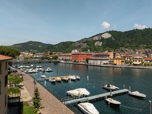 Una marina con imbarcazioni ormeggiate, un fiume e edifici lungo la riva.