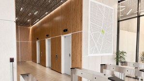 A modern lobby with wooden paneling, a digital map display, and a self-service kiosk. - Apartment with incredible city view (Bogotá)