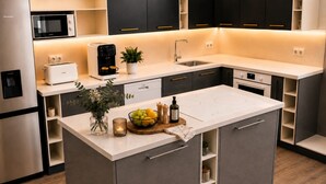 A modern kitchen with a central island, built-in appliances, and a minimalist design. - The Nathéa Suite, 10 minutes from Sainte-Maxime (Roquebrune-sur-Argens)