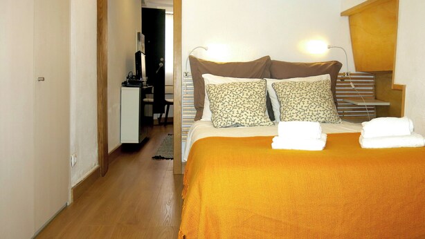 Une chambre à coucher avec un lit, des oreillers, un bureau et une chaise.