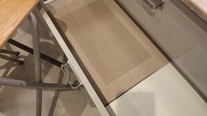Una cucina con un piano di lavoro, un lavello e un cassetto dotato di un inserto a rete.