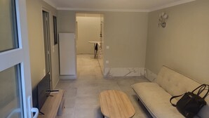 Un soggiorno moderno con un divano, un tavolino in legno e una lampada a sospensione.