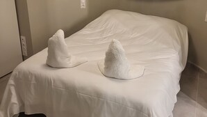 Un letto rifatto con due asciugamani bianchi sopra.
