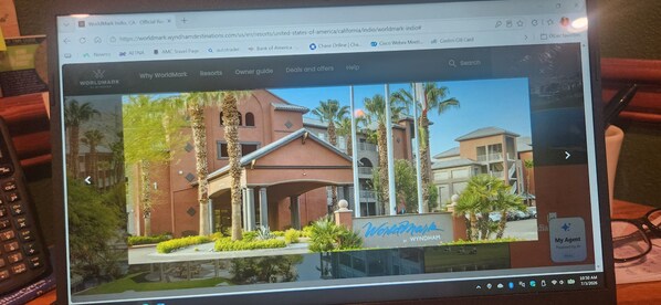 Eine Webseite mit einem großen Foto eines Gebäudes mit der Aufschrift 'WorldMark', das den Eingangsbereich und umliegende Palmen zeigt.
