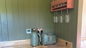 A kitchenette with a wooden countertop, a coffee maker, a toaster, and a trash bin. - Shepherd's Hut with mountain and valley views on the Mach Loop flightpath (Dolgellau)
