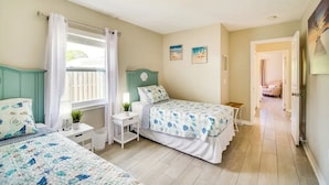 A bedroom with two beds, a desk, and a window with curtains. - 3-bedroom house in peaceful Melbourne with cool AC (Melbourne)