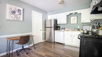 A kitchen with a refrigerator, stove, and cabinets.