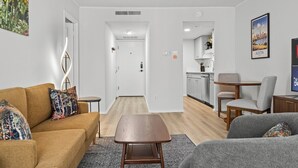 Un salon moderne comprenant un canapé, une table basse et un coin repas avec des chaises.