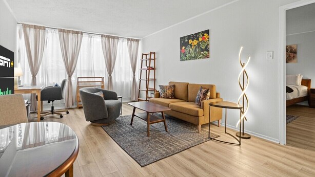 Un salon moderne comprenant un canapé, un fauteuil, une table basse et un bureau avec une chaise.