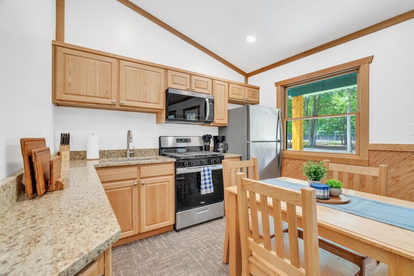 A kitchen with wooden cabinets, a microwave, a stove, and a refrigerator.