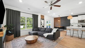 A modern living room with a sofa, coffee table, and a ceiling fan. - Coastal Retreat / Near 30A / Pool / 4BR / Sleeps 10 (Santa Rosa Beach)