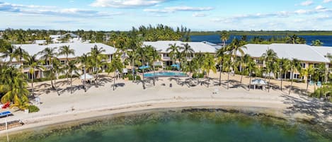 Un resort con piscina, playa y vista al océano.