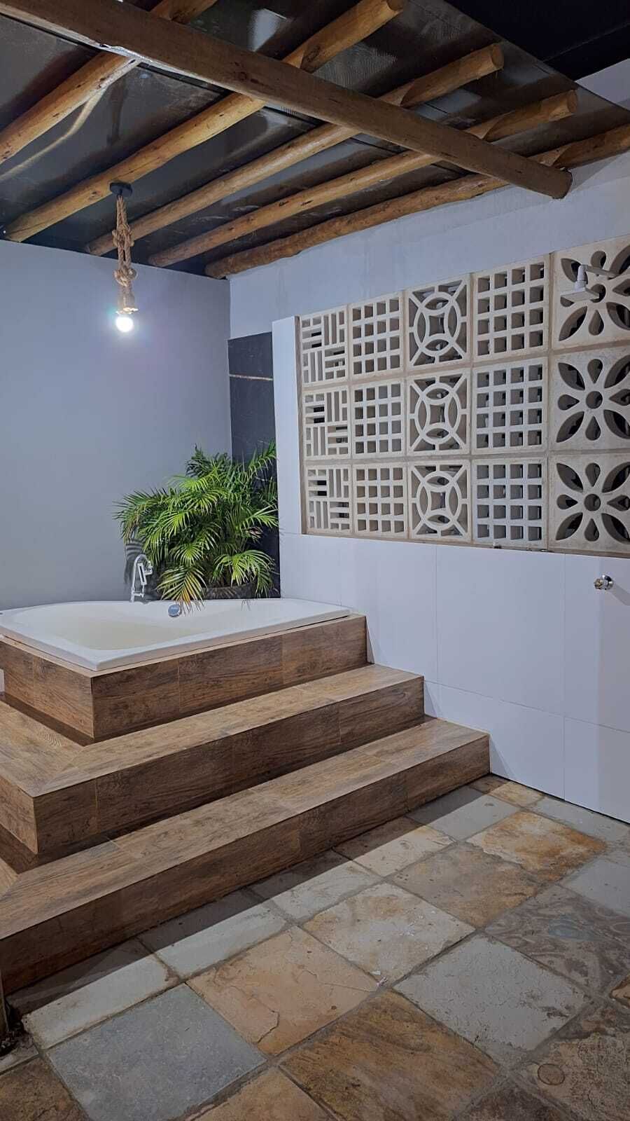 Ein Badezimmer mit einer Holztreppe, einer Badewanne und einer dekorativen Wandverkleidung.