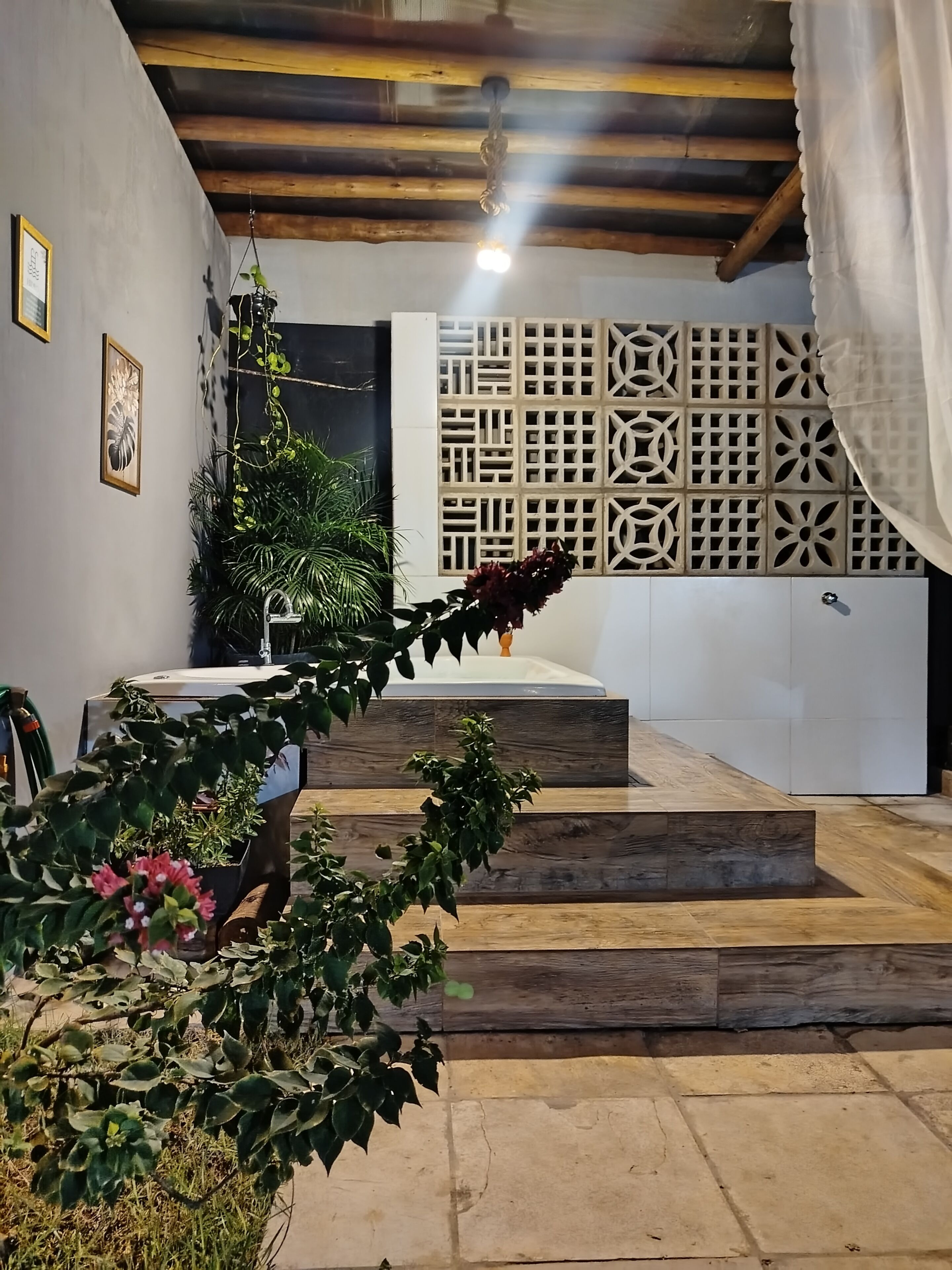 Una escalera conduce a un dormitorio con un panel decorativo en la pared y una planta colgante.