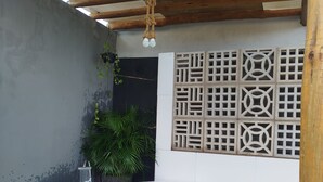 A spa area with a hot tub, wooden steps, a wall-mounted water feature, and a ceiling with a wooden beam structure. - Chácara Recanto do Sítio (Barbalha)
