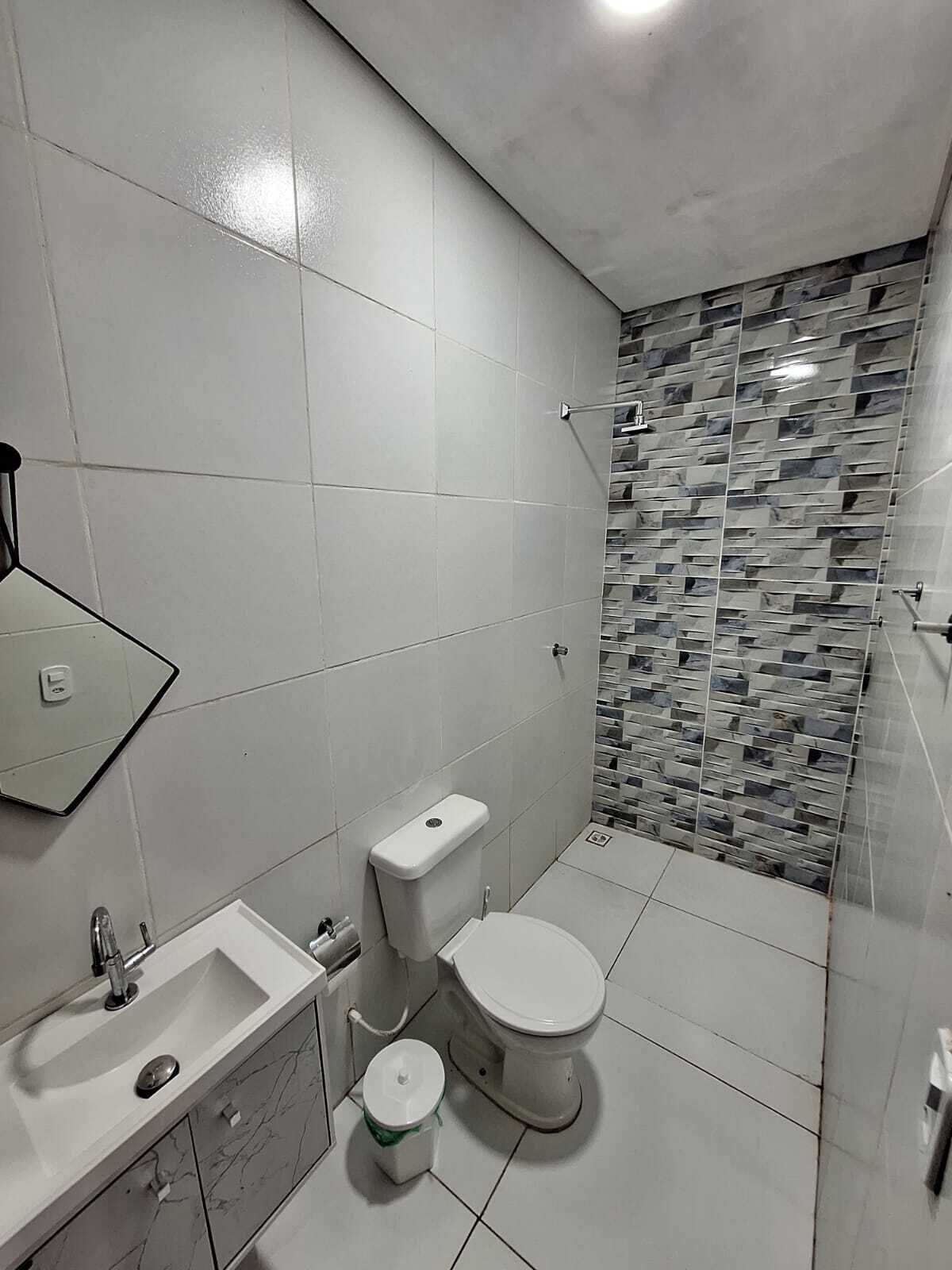 Ein modernes Badezimmer mit Toilette, Waschbecken und Duschbereich.