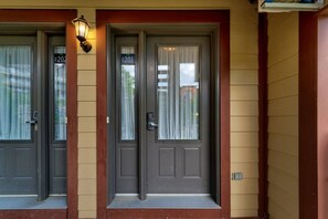 Two dark grey doors with glass panels and a small step leading up to the entrance.